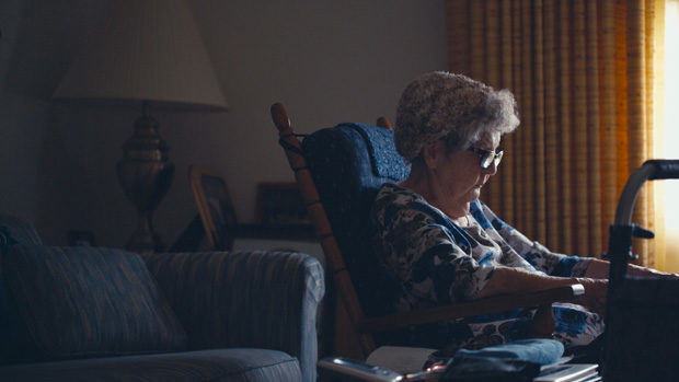 An elderly woman reading in a chair 